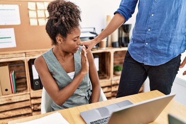 Woman uncomfortable at being touched without her consent by male colleague.