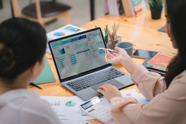 two women looking at a laptop