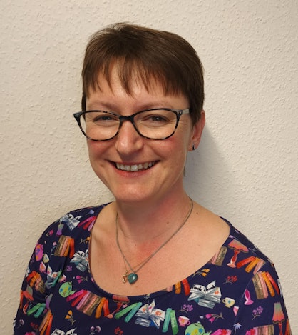 A smiling woman wearing glasses