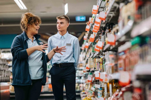 a man and woman in supermarket uniform