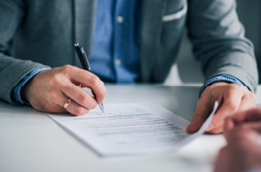 man signing an important document