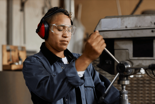 Machinery operator in factory with eye protection