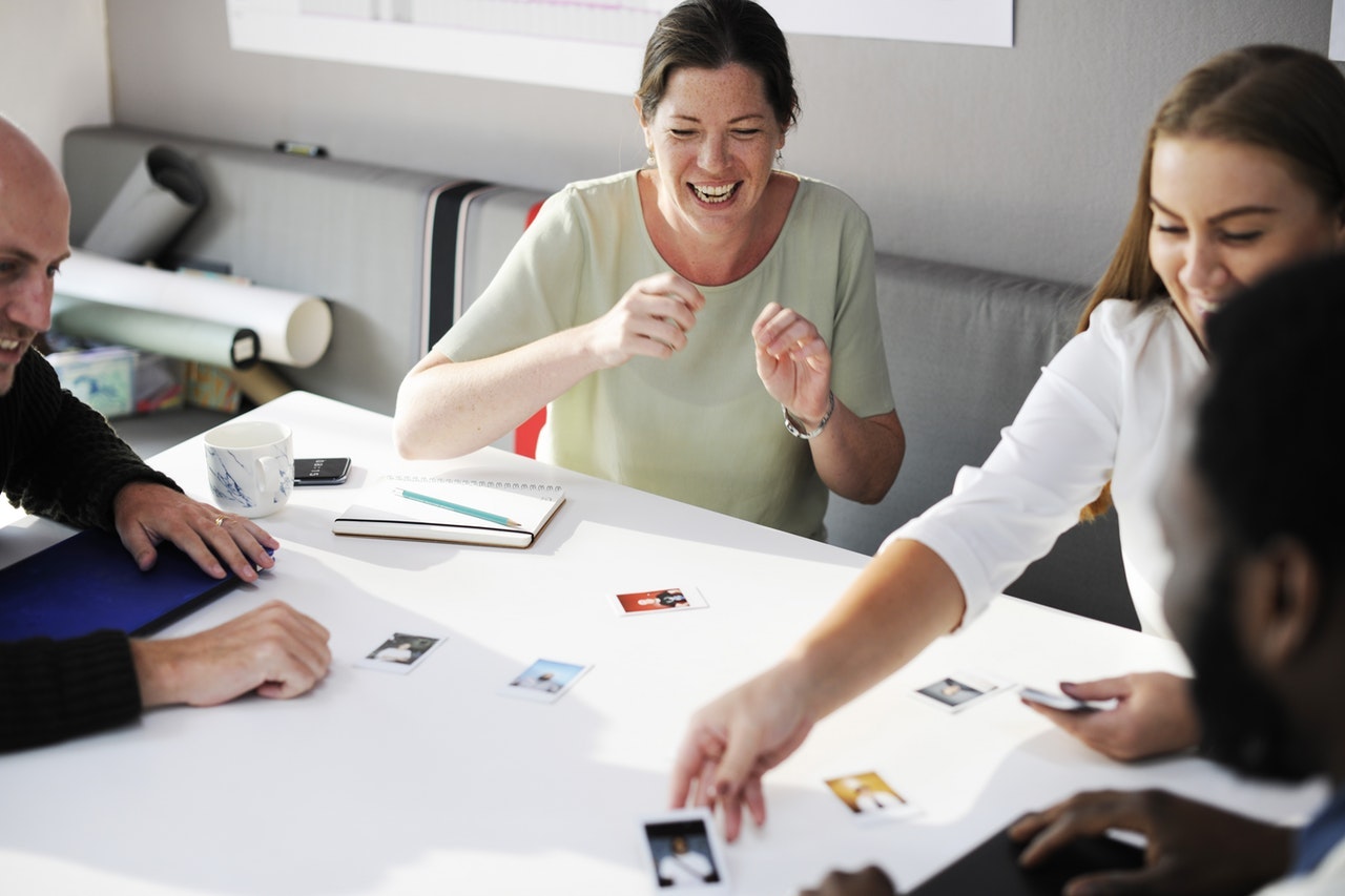 A team gathered around a table looking at pictures.