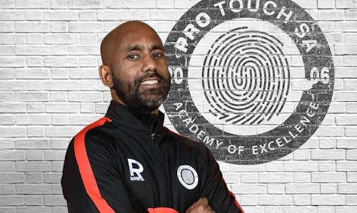 A man wearing sports wear in front of a logo that says Pro Touch SA, Academy of Excellence