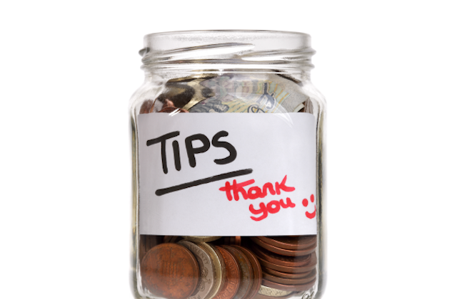 a glass jar of tips with label saying tips thank you smiley face