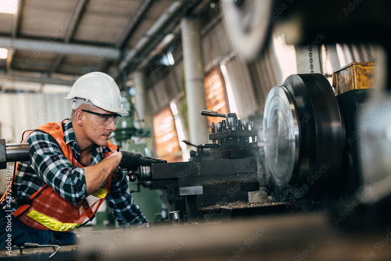 A man using a work device with safety guards.