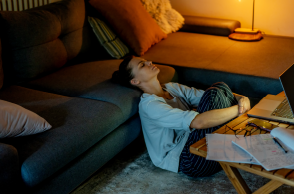 woman sits on floor of apartment exhausted
