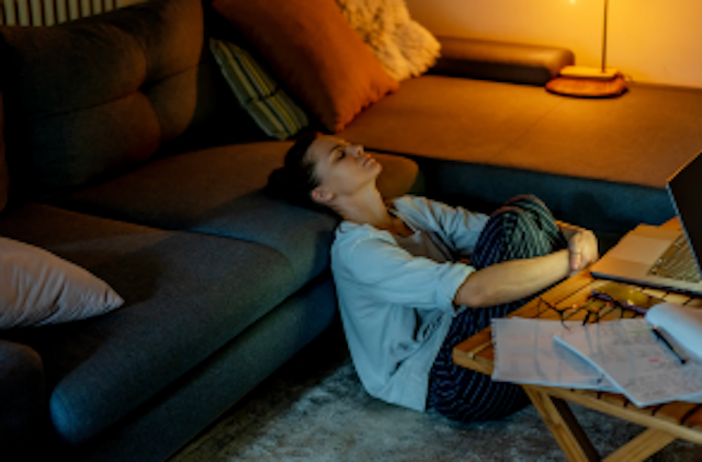 woman sits on floor of apartment exhausted