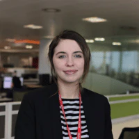 A woman wearing a blazer and striped top.