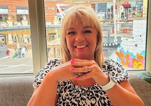 A smiling woman with blonde hair.
