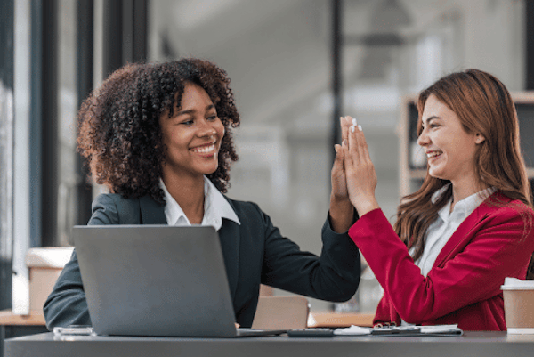 HR Management Software - An employer high-fiving their staff whilst using Peninsula's HR Management Software.