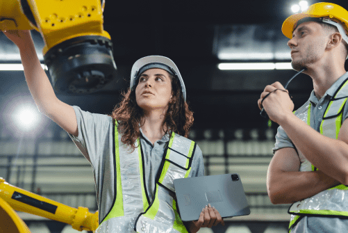 Workers in yellow hard hats inside a warehouse