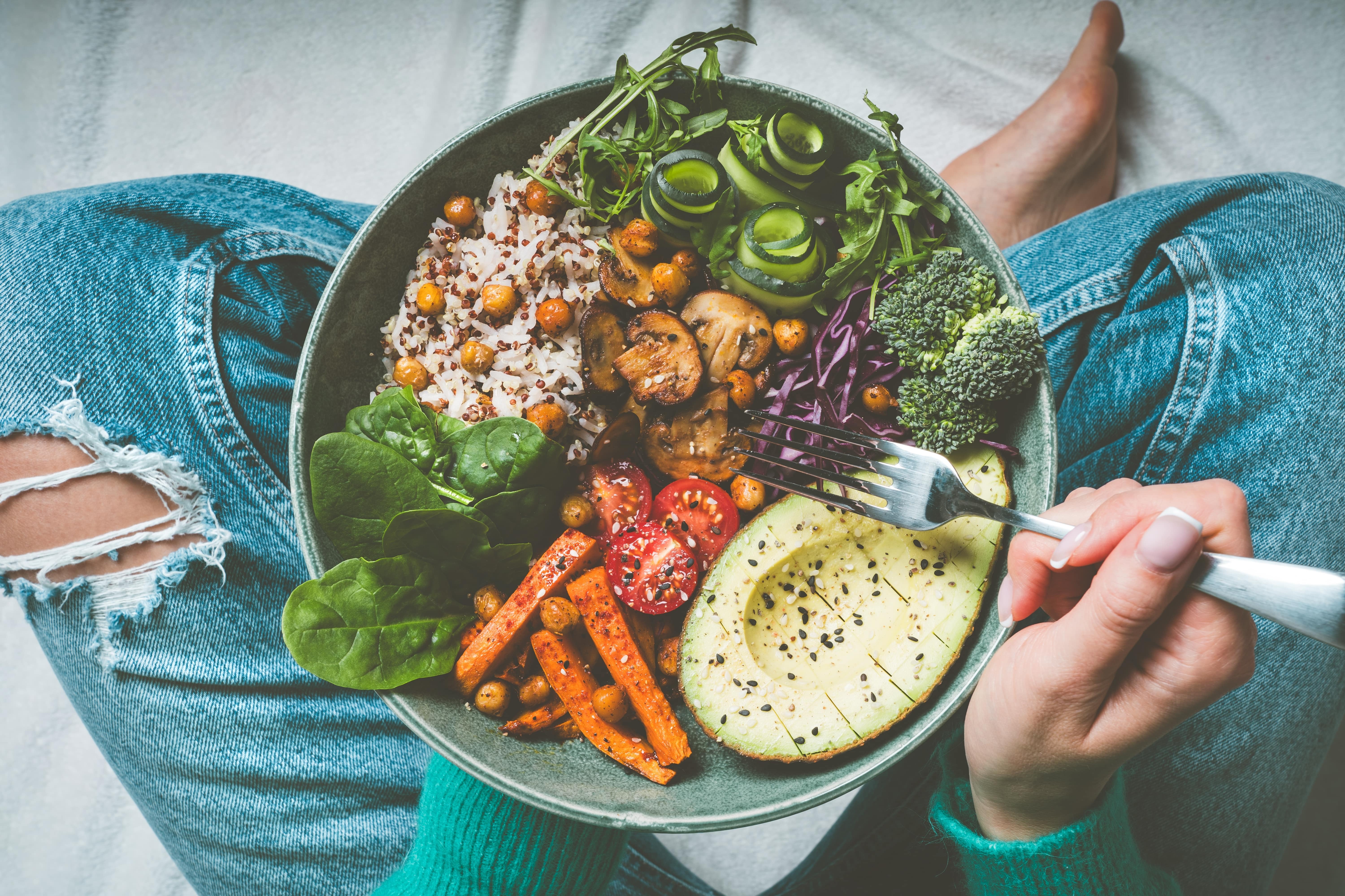 This image showcases a vibrant and healthy Buddha bowl with quinoa, chickpeas, roasted sweet potatoes, avocado, spinach, and tofu—evoking mindful, whole-food eating.