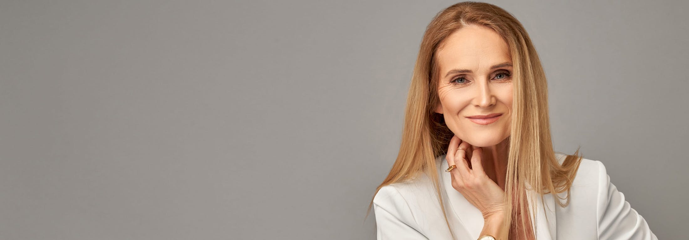 Middle-aged woman with blonde hair wearing a white blouse