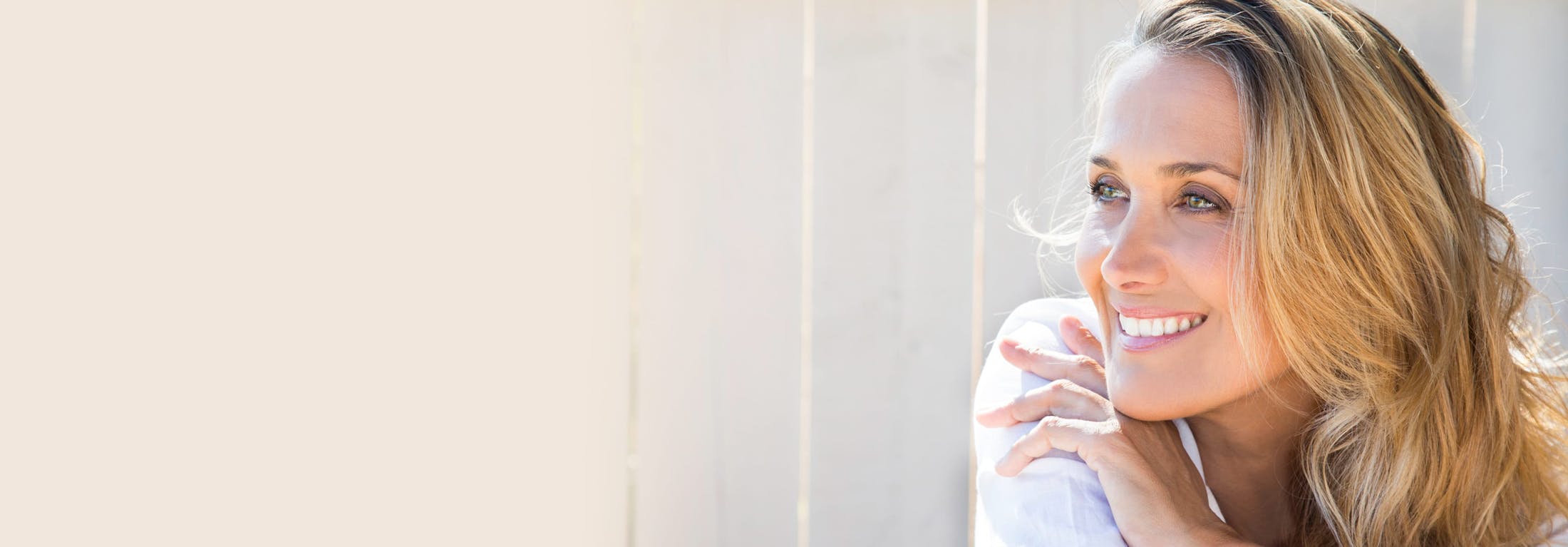 woman smiling with hand on shoulder