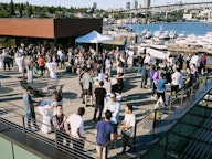 An aerial photo of from an AI2 company party showing people on a sunny deck in Seattle.