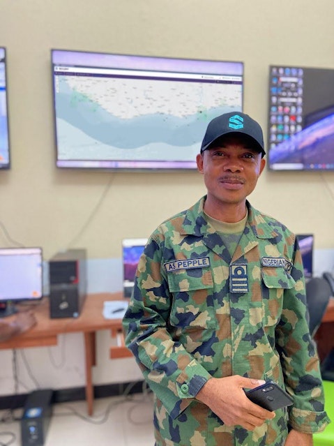 A user of Skylight stands in front of a monitor displaying maritime activity.