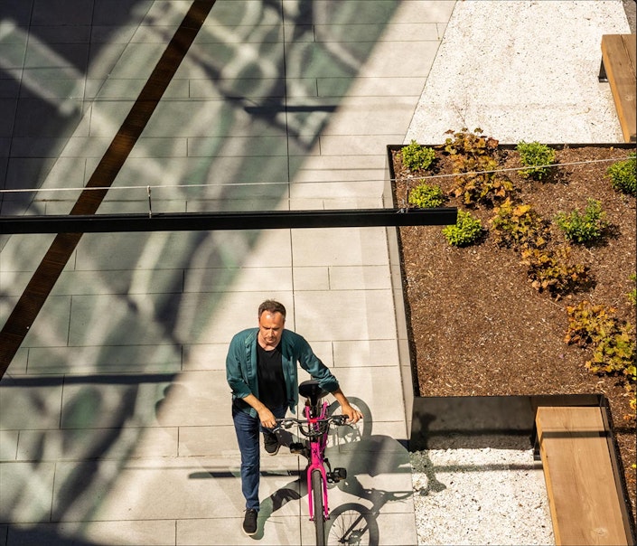 Ai2 employee walking their bike into the new office.