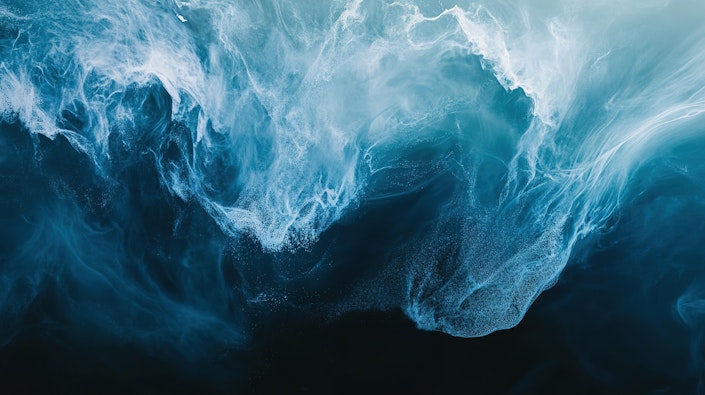 Dynamic ocean waves crashing during sunset, showcasing vibrant blues and foamy textures in a coastal scene.
