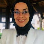 Bu gözlüklü ve başörtülü bir kadının görüntüsüdür. Açık tenli, uzun kumral saçlı ve koyu renk gözlü. Gözlükleri ince ve dikdörtgen şeklinde, kahverengi çerçeveli ve siyah camlıdır. Başörtüsü açık mavi ve beyaz renktedir ve başının etrafına bir fiyonkla bağlanmıştır. Hafif bir gülümsemesi var ve rahat görünüyor. Beyaz bir tişört ve mavi kot pantolondan oluşan gündelik bir kıyafeti var. Arka planda bir pencere bulunan beyaz bir duvarın önünde duruyor.