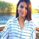 Bu fotoğrafta siyah beyaz çizgili, uzun kollu gömlek giyen bir kadın görülüyor. Koyu renk saçları yüzünden geriye doğru toplanmış ve ela gözleriyle dümdüz karşıya bakıyor. Yüzünde kendinden emin bir ifade var ve dudakları hafifçe ayrılmış. Köprücük kemiği görünüyor ve ince bir vücuda sahip. Arka plan düz beyaz bir duvar ve kadın duvarın önünde kollarını kavuşturmuş bir şekilde duruyor. Kıyafetini bir çift siyah, topuklu bot tamamlıyor ve elleri birkaç gümüş yüzükle süslenmiş. Yirmili yaşlarının sonlarında olduğu anlaşılıyor ve kıyafeti ona rahat ama şık bir görünüm veriyor.