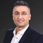 Özel dikim siyah takım elbiseli yakışıklı bir adam gri bir arka planın önünde kendinden emin bir şekilde duruyor. Kısa, koyu renk saçları ve hafif bir sakalı var ve gözleri uzaklara bakıyor. Duruşu rahat, elleri rahatça ceplerinde ve dudaklarında hafif bir gülümseme var. Zarif ve sofistike görünüyor ve hayatın sunacağı her şeyi üstlenmeye hazır. Beyaz gömleği ve siyah kravatıyla kıyafetini tamamlıyor ve görünümüne sofistike bir hava katıyor.