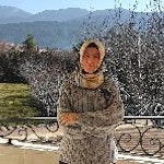 Genç bir kadın balkonda durmuş, uzaklara bakmaktadır. Beyaz bir gömlek ve koyu mavi bir kot pantolon giyiyor. Saçlarını topuz yapmış ve yüzünde sıcak bir gülümseme var. Balkon, uzakta tepelerin ve ağaçların yer aldığı huzurlu bir manzaraya bakmaktadır. Güneş batıyor ve gökyüzü turuncu, sarı ve pembenin güzel bir karışımı. Kadın ellerini korkuluklara dayamış, kendinden emin bir şekilde durmakta ve merakla dışarı bakmaktadır. O anın güzelliğine kapılmış, yüzünde neşe ve memnuniyet ifadesi var.