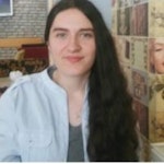Resimde uzun, siyah saçlı, gözleri kapalı ve yüzünde geniş, içten bir gülümseme olan bir kadın görülüyor. Sırtını dik tutmuş, kolları iki yanında, saçları omuzlarından ve sırtından aşağı dökülüyor. Yirmili yaşlarında görünüyor ve ten rengini tamamlayan beyaz bir bluz giyiyor. Memnun ve neşeli görünüyor, bir güven ve duruş havası yayıyor. İfadesi ve duruşu huzur ve dinginlik hissi veriyor. Uzun saçları güzelliğine ve kadınsılığına katkıda bulunarak mutlu ve kaygısız bir kadın resmini tamamlıyor.