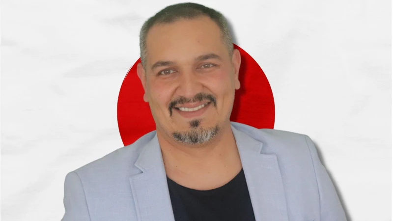 Bu, Japon bayrağının önünde gülümseyen bir adamın fotoğrafı. Geleneksel kıyafetler giydiği görülüyor, bu da kültürün bir parçası olduğunu gösteriyor. Bu resim Japonya'nın dilini ve kültürünü öğrenmenin önemini sembolize ediyor olabilir. Konuşma eğitimine katılarak Japon kültürü ve sosyal görgü kuralları hakkında bir fikir edinebiliriz. Bu, daha iyi bir anlayış ve iletişimin anahtarı olabilir ve Japonlarla anlamlı konuşmalar yapmamızı sağlayabilir. Dil öğrenmek, kültürü deneyimlemek ve topluma daha fazla entegre olmak için harika bir yoldur.