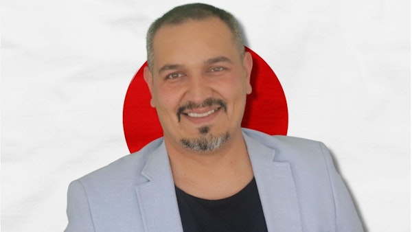 Bu, Japon bayrağının önünde gülümseyen bir adamın fotoğrafı. Geleneksel kıyafetler giydiği görülüyor, bu da kültürün bir parçası olduğunu gösteriyor. Bu resim Japonya'nın dilini ve kültürünü öğrenmenin önemini sembolize ediyor olabilir. Konuşma eğitimine katılarak Japon kültürü ve sosyal görgü kuralları hakkında bir fikir edinebiliriz. Bu, daha iyi bir anlayış ve iletişimin anahtarı olabilir ve Japonlarla anlamlı konuşmalar yapmamızı sağlayabilir. Dil öğrenmek, kültürü deneyimlemek ve topluma daha fazla entegre olmak için harika bir yoldur.