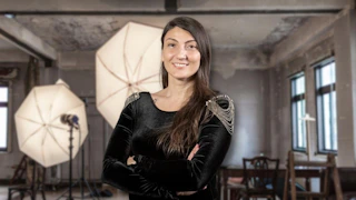 Bu görüntü, fotoğraf çekme teknikleri üzerine çevrimiçi bir kursa aittir. Siyah elbiseli, kollarını kavuşturmuş bir kadın ve arka planda bir ekipman stüdyosu yer alıyor. Kadın yakın planda, gülümseyerek ve kendinden emin bir şekilde çerçevelenmiş ve fotoğrafın odak noktası haline getirilmiş. Stüdyonun etrafındaki aydınlatma armatürleri ve ekipmanlar görüntünün atmosferine katkıda bulunarak fotoğrafçılıkta teknikte ustalaşmanın önemini vurgulamaktadır. Bu kurs, fotoğraf çekme tekniklerine kapsamlı bir genel bakış sağlayarak katılımcılara kompozisyon, ışıklandırma ve mükemmel çekimi ayarlamanın temellerini öğretir. Ayrıca, öğrencilere konu veya stil ne olursa olsun çarpıcı görüntüler oluşturmak için fotoğraf makinelerini kullanma bilgi ve becerisi kazandırır. İster yeni başlayan ister deneyimli bir fotoğrafçı olun, bu kurs potansiyelinizi ortaya çıkarmanıza ve güzel fotoğraflar oluşturmanıza yardımcı olabilir.