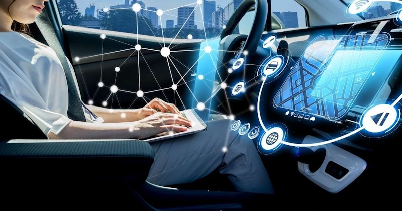 Bir adam arabada oturmuş dizüstü bilgisayar kullanıyor. Elinde üzerinde harita olan bir cihaz var. Adam dizüstü bilgisayara odaklanmış, diğer eli klavyenin üzerinde duruyor. Yüzü dizüstü bilgisayar ekranı tarafından aydınlatılıyor. Görüntünün sol tarafında bir çipin yakın çekimini görebiliyoruz. Sağ üst köşede siyah kenarlıklı beyaz bir nesne var. Görüntünün sağ alt köşesinde bir küre logosu yer alıyor. Görüntünün arka planında binalar ve noktalardan oluşan bir şehir manzarası yer alıyor.