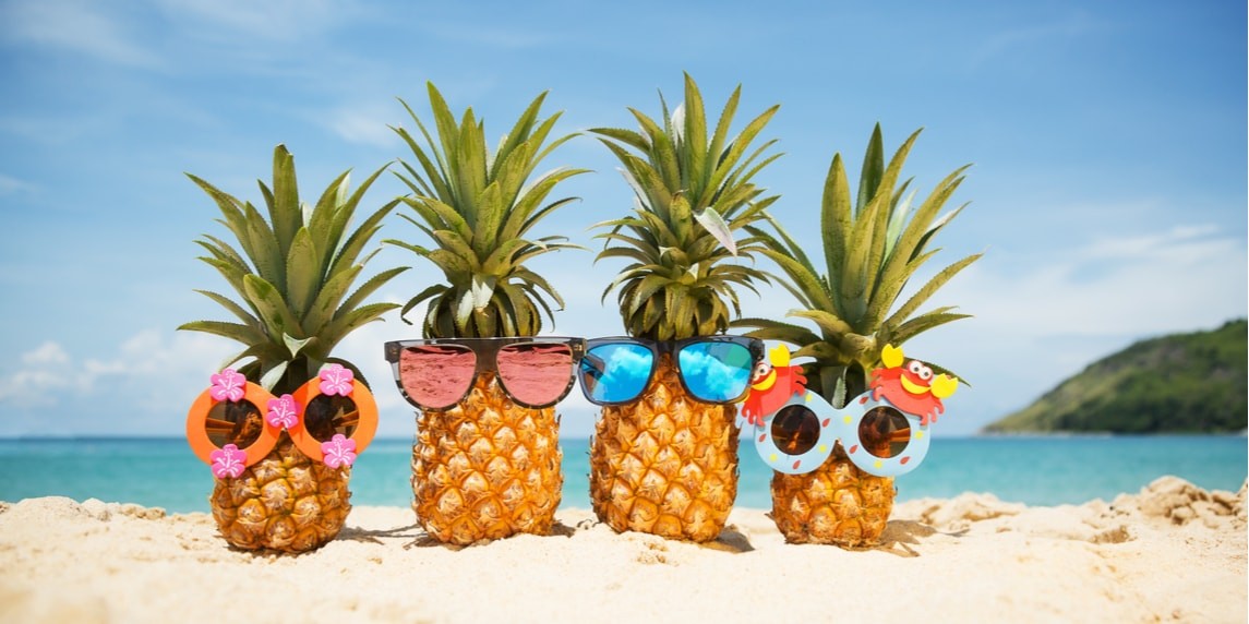 Bu görüntüde sahilde uzanmış, her ikisi de mavi camlı parlak sarı güneş gözlükleri takmış iki ananas görülüyor. Ananasların etrafındaki kum kumlu kahverengi bir renktedir ve arka plandaki okyanus koyu turkuaz mavisidir. Uzakta, birkaç ağacın göründüğü bir tepenin bulanık bir görüntüsü var. Güneş pırıl pırıl parlıyor, suyun üzerinde bir ışıltı ve güneş gözlüklerinin camlarında bir parıltı yaratıyor. Ananasların etrafı sahilde, her ikisi de güneş gözlüğü takmış iki yüzlü bir yengeç de dahil olmak üzere birkaç başka nesne ile çevrili. Güneş gözlüklerinin parlak sarısı kumda göze çarpıyor ve mavi camlar sarı çerçevelerle hoş bir kontrast oluşturuyor. Genel olarak, bu neşeli ve yazlık bir sahne.