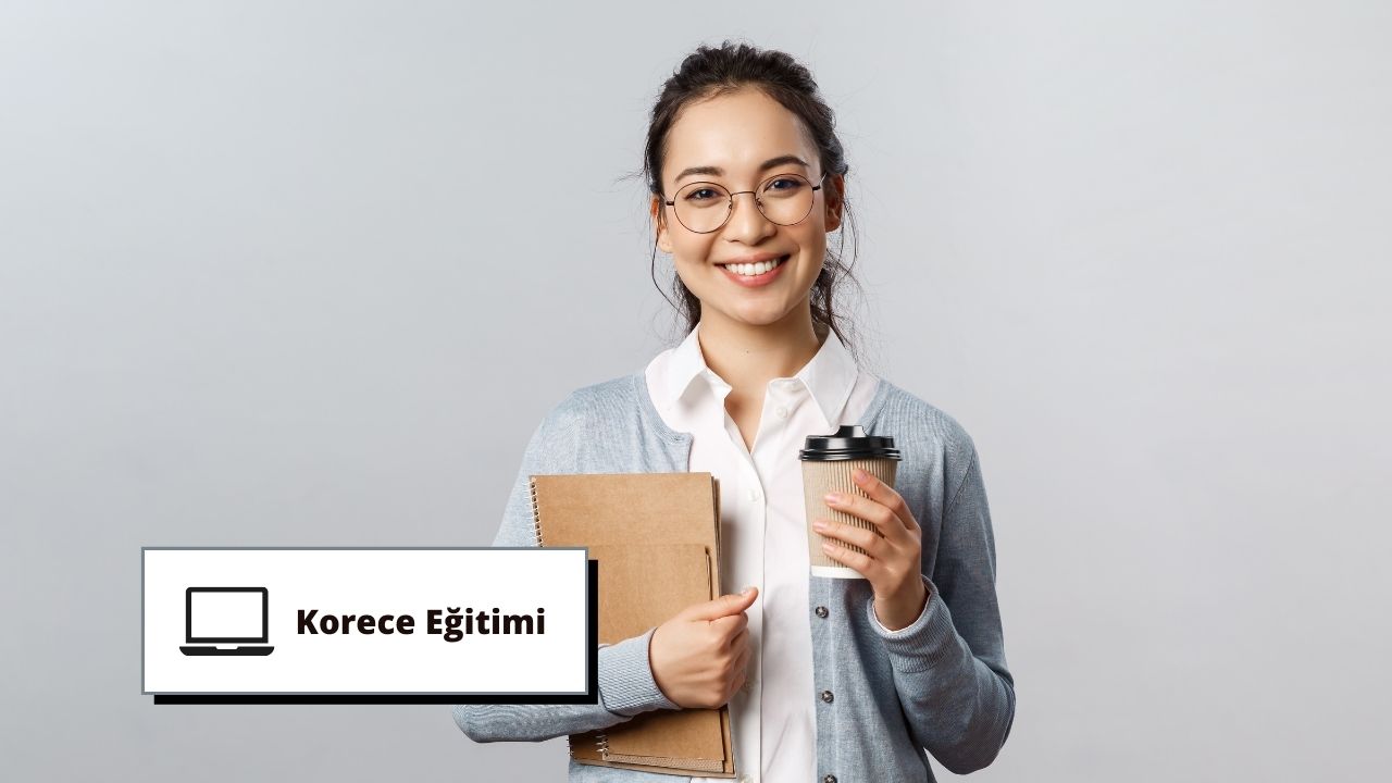 Gözlüklü bir kadın elinde bir kahve fincanı ve bir defter tutarken gülümsüyor. Defter açık ve kadın dikkatle yere bakıyor, elindeki işe odaklanıyor. Kahve fincanı beyaz, sapı koyu kahverengi ve defterin üzerine gri bir örtü örtülmüş. Arkasındaki duvar düz beyazdır ve arka planda kahverengi bir karton üzerine yazılmış siyah bir metin vardır. Kadın rahat bir kıyafet giymiş ve yüzü hoş bir ifadeyle aydınlanmış. Gözleri kararlılıkla odaklanmış ve o anda yapmakta olduğu faaliyete dalmış durumda.