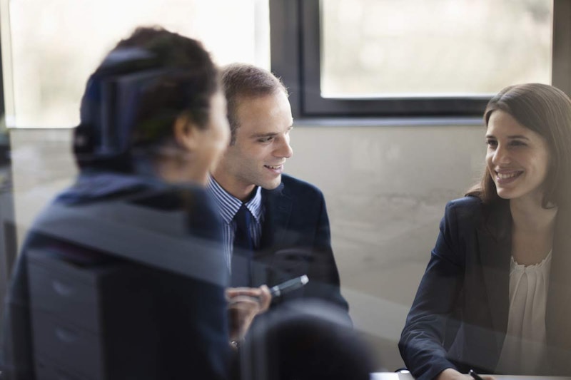 Beş kişilik bir grup büyük bir ahşap masanın etrafında toplanmıştır. Grubun ortasındaki kadın kameraya bakarken ışıl ışıl gülümsüyor. Kadının sağında bir adam yüzünde hafif bir gülümsemeyle yana bakıyor. Başına yakın çekim yapıldığında sakin ifadesi ortaya çıkıyor. Görüntünün ön planında, başka bir kişinin bulanık yüzü zar zor görülebiliyor. En solda, gözleri kapalı ve dişleri görünecek şekilde gülümseyen bir adamın yakın çekimi görülüyor. En sağda, gözleri kapalı ve ağzı hoş bir gülümsemeyle kıvrılmış bir kadının yakın çekimi görülüyor. Bir grup insan birbirine yakın oturmakta ve anın tadını çıkarmaktadır.