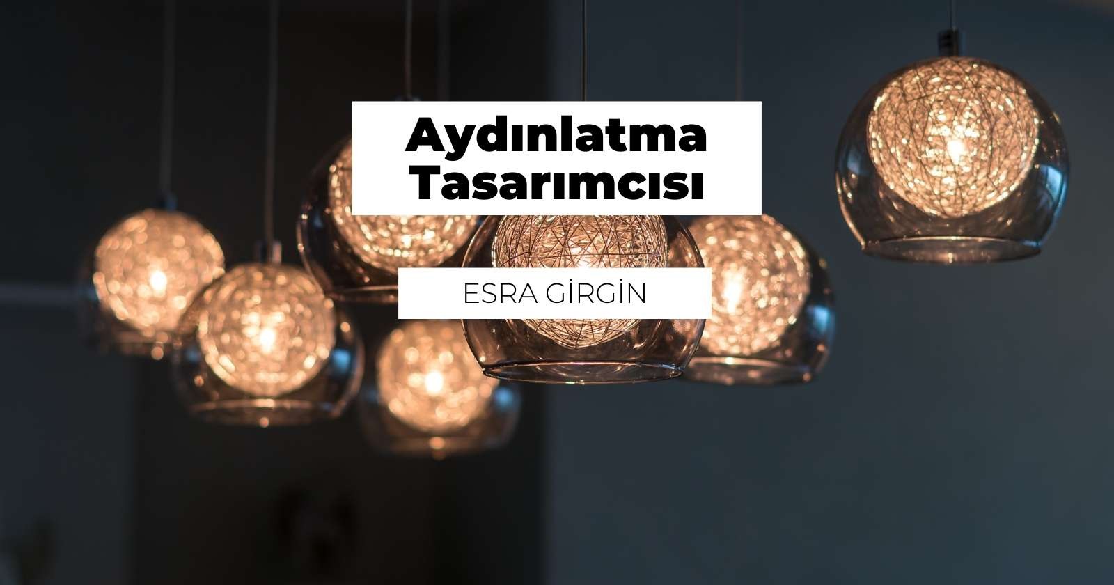 Tavandan bir grup cam ışık odanın içinde asılı durmaktadır. Görüntünün ortasında, içinden ışık geçen beyaz bir kürenin yakın çekimi yer alıyor. Sağ üst köşede camlı bir ışığın yakın çekimi var ve üzerinde beyaz bir etiket görülebiliyor. Sol alt köşede de camlı başka bir ışığın yakın çekimi var. Ayrıca, sol üst köşede dairesel bir ışığın bulanık bir görüntüsü ve sağ alt köşede bir kürenin bulanık bir görüntüsü var. Daha sağda bir kadeh şarabın yakın çekimi var. Görüntünün ortasında siyah metinli beyaz bir tabela var. Tüm ışıklar yanıyor ve parlak bir atmosfer yaratıyor.