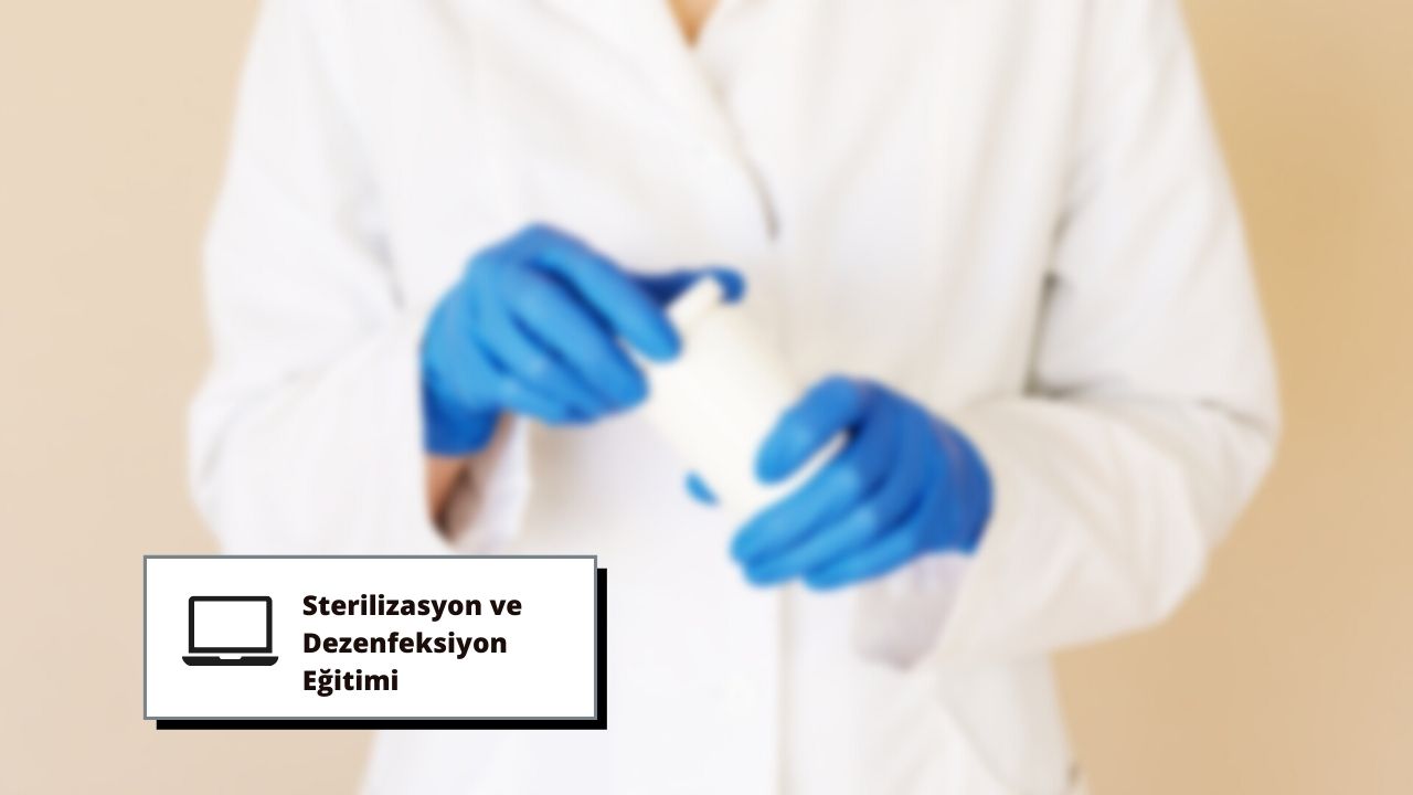 Bu görselde mavi eldiven giymiş ve elinde bir kap tutan bir kişi görülmektedir. Bu kişi muhtemelen sterilizasyon ve dezenfeksiyon eğitimi vermekte ve kabın bakteri ve diğer kirleticilerden arındırılmasını sağlamaktadır. Kişinin eldivenlerinin yakın çekimi, bu süreçte koruyucu donanımın önemini göstermektedir. Bu kurs, ortamları hijyenik ve güvenli tutmak için gereklidir.