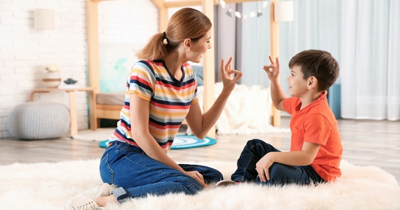 Bir kadın ve genç bir çocuk aydınlık bir odada yerde oturmaktadır. Kadının üzerinde çizgili bir gömlek ve mavi bir kot pantolon vardır ve saçları at kuyruğu şeklinde geriye doğru toplanmıştır. Çocuk ise açık renkli bir gömlek ve kot pantolon giymektedir. Yüzünde mesafeli bir ifadeyle kameradan uzağa bakmaktadır. Önlerinde siyah kenarlıklı beyaz, yuvarlak bir puf var. Etraflarında ahşap zemin ve duvarlar var. Huzurlu ve dingin bir atmosfer içindeler ve kameranın varlığından habersiz görünüyorlar.