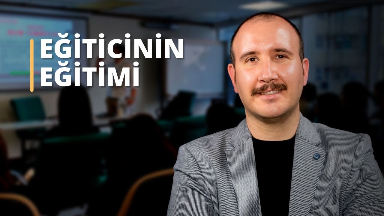Bu görüntü, gömlek giyen bıyıklı bir adamın yakın çekimidir. Hafifçe gülümsüyor ve çenesi görünüyor. Yüzü siyah bir arka planla çerçevelenmiş ve gözleri, burnu ve ağzı net bir şekilde görülebiliyor. Bıyığı kıvrımlı ve uzun, üst dudağının üzerinden ağzının bir tarafına doğru uzanıyor. Giydiği gömlek çoğunlukla beyazdır ve yakası boynunun etrafında görünmektedir. Elleri görünmüyor, ancak resmin sağ üst köşesinde bir kişinin elinin bulanık bir resmi görülebiliyor. Bıyıklı adamın bu portresi, bir insanın yüzünü ve ifadesini gösteren harika bir örnektir.