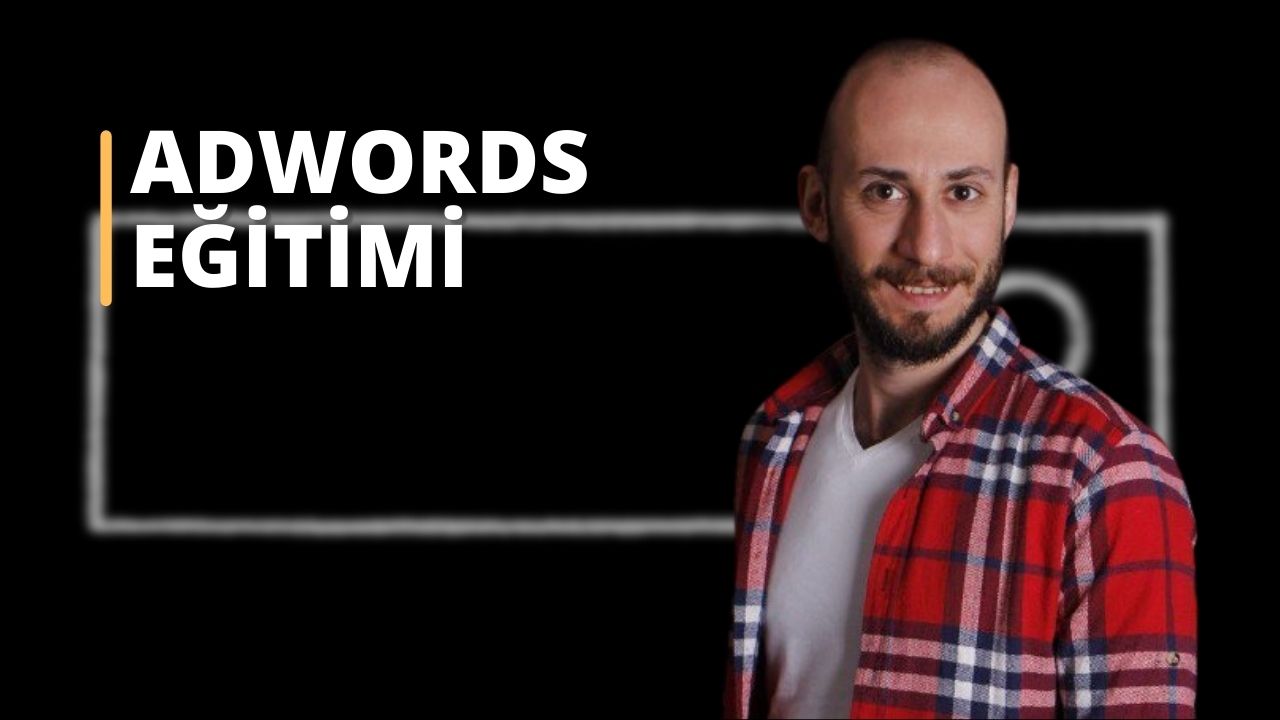 Bu görüntü kırmızı ve siyah ekose pazen gömlekli bir adamı gösteriyor. Tam sakallı ve saçları yüzünün yanlarından görünüyor. Gömlek yakasına kadar düğmeli ve kırmızı renk gömleğe hakim. Gömleğin kumaşı dokulu ve küçük siyah ve beyaz karelerle dokunmuş. Adam düz beyaz bir arka plan üzerinde durmaktadır. Hafifçe sola bakıyor ve ifadesi nötr. Kolları yanında dik durmaktadır ve elleri görüntüde görünmemektedir.