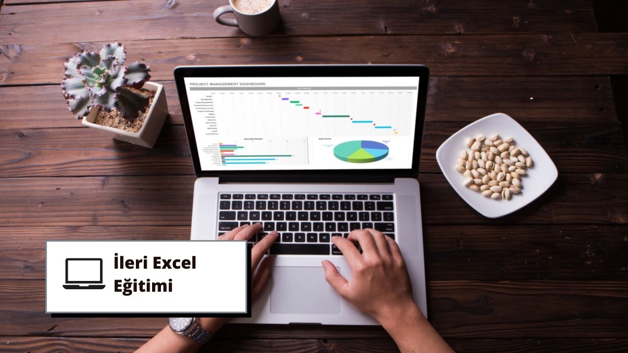 Bu görselde ileri Excel eğitimi için dizüstü bilgisayar kullanan bir kişi yer almaktadır. Dizüstü bilgisayar açık ve kullanıcı klavyede yazıyor, bu da kursa aktif olarak katıldığını gösteriyor. Arka planda, öğrenme atmosferine katkıda bulunan siyah metinli bir tabela ve ahşap bir yüzey üzerinde bir tabak antep fıstığı görülebiliyor. Ayrıca, muhtemelen kurs sırasında içilen bir fincan kahvenin yakın çekimi ve rahatlatıcı ve konforlu bir ortam yaratan bir bitkinin yakın çekimi de bulunmaktadır. Dizüstü bilgisayar ekranında, kullanıcının aktif olarak verileri analiz ettiğini gösteren bir grafik görülebiliyor. Tüm bunlar bir araya gelerek bu ileri düzey Excel eğitim kursu için ideal bir öğrenme ortamı oluşturuyor.