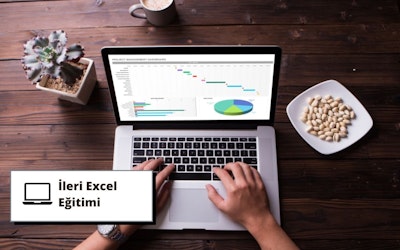 Bu görselde ileri Excel eğitimi için dizüstü bilgisayar kullanan bir kişi yer almaktadır. Dizüstü bilgisayar açık ve kullanıcı klavyede yazıyor, bu da kursa aktif olarak katıldığını gösteriyor. Arka planda, öğrenme atmosferine katkıda bulunan siyah metinli bir tabela ve ahşap bir yüzey üzerinde bir tabak antep fıstığı görülebiliyor. Ayrıca, muhtemelen kurs sırasında içilen bir fincan kahvenin yakın çekimi ve rahatlatıcı ve konforlu bir ortam yaratan bir bitkinin yakın çekimi de bulunmaktadır. Dizüstü bilgisayar ekranında, kullanıcının aktif olarak verileri analiz ettiğini gösteren bir grafik görülebiliyor. Tüm bunlar bir araya gelerek bu ileri düzey Excel eğitim kursu için ideal bir öğrenme ortamı oluşturuyor.