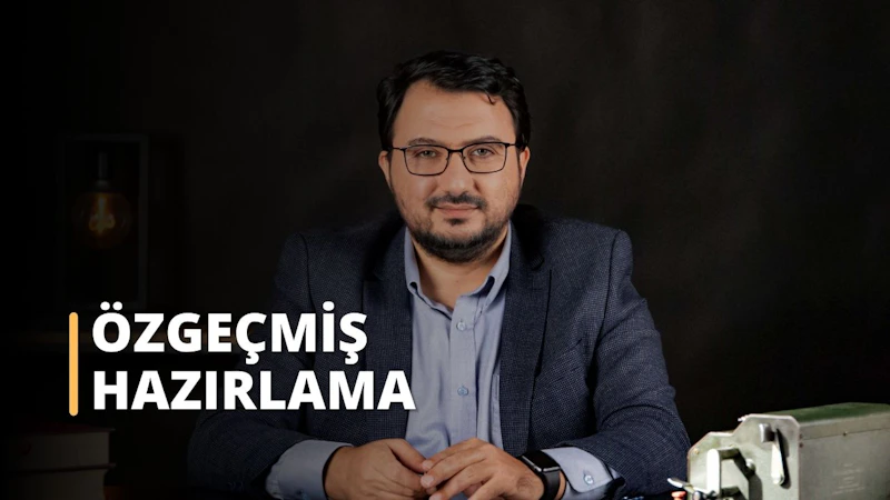 Resimde muhtemelen bir CV görüşmesine hazırlanan takım elbiseli bir adam görülüyor. Gözlüklü, sakallı ve düğmeli gömleğiyle kendinden emin ve iyi giyimli görünüyor. Arka planda metal bir kutunun yakın çekimi, bir saat ve bir kol görülebiliyor. Bu görüntü, bir CV görüşmesine nasıl hazırlanılması gerektiğine dair mükemmel bir örnektir.