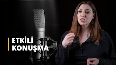 Bu görüntüde mikrofona konuşan bir kadın görülmekte olup, Doğru ve Etkili Konuşma Teknikleri Eğitimine katıldığını göstermektedir. Siyah bir gömlek giymiş, kolye takmış ve uzun saçlarıyla kursu ciddiye aldığını gösteriyor. Arka planda siyah beyaz bir fotoğraf var, bu da kursta konuşurken doğru tonda konuşmanın öneminin tartışıldığını gösteriyor. Bir konuşmacının yakın çekimi de kurstaki ses unsurunun önemini göstermektedir. Son olarak, konuşurken fiziksel jest ve hareketlere duyulan ihtiyacı vurgulayan bir elin yakın çekimi görülmektedir. Bu kurs, bireylerin doğru ve etkili konuşmayı öğrenmelerine yardımcı olmak için tasarlanmıştır, böylece kalıcı bir izlenim bırakabilir ve çabalarında başarılı olabilirler.