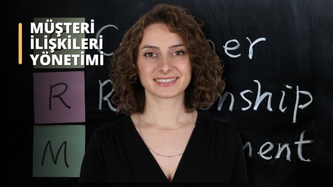 Bu görsel, müşteri ilişkileri yönetimi (CRM) alanında çevrimiçi bir kursu göstermektedir. Bir kadın kara tahtanın önünde gülümseyerek duruyor. Kolye takıyor ve kıvırcık saçları yüzünü çerçeveliyor. Kara tahta, kurs hakkında bilgi veren beyaz metinlerle doludur. Buna ek olarak, pembe bir arka plan üzerinde kursa daha fazla bağlam kazandıran bir mektup görülüyor. Daha yakından bakıldığında, kadının burnu yakından görülebiliyor. Bu görsel, CRM kursuna harika bir genel bakış sağlar ve müşteri ilişkilerinin önemini görsel olarak hatırlatır.