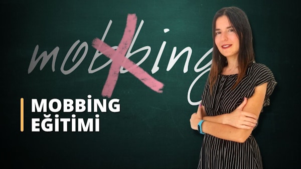 Bir kadın kara tahtanın önünde duruyor. Kollarını kavuşturmuş ve yüzünde şaşırtıcı derecede sıcak bir gülümseme var. Uzun, siyah saçları arkaya toplanmış ve üzerinde rahat, açık renkli bir gömlek var. Kara tahtanın üzerinde beyaz bir metin ve farklı renklerde birkaç şekil ve diyagram yazılı. Kadın kendinden emin ve memnun görünüyor, önündeki tahtada yazılı olan bilgileri bir an için kavrıyor. Görüntü kara tahtanın yakın çekimidir ve metnin ve diyagramların karmaşık ayrıntılarını göstermektedir. Kadının varlığıyla çerçevelenen genel kompozisyon, çevreye benzersiz bir bakış açısı sağlıyor.