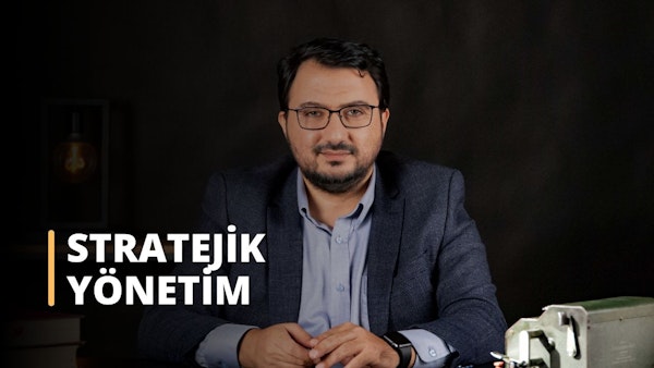 Bu görsel, Stratejik Yönetim üzerine çevrimiçi bir kursa aittir. Resimde takım elbise giymiş, masa başında oturan bir adam görülüyor. İzleyici ön planda metal bir kutunun, bir saatin, bir kişinin gözlerinin, düğmeli bir gömleğin ve bir adamın yüzünün yakın çekimini görebilmektedir. Arka planda da beyaz bir metnin yakın çekimi bulunmaktadır. Stratejik Yönetim dersi, öğrencilere etkili iş stratejileri planlamak ve uygulamak için gerekli bilgi ve araçları sağlayacaktır. Bu ders sayesinde öğrenciler potansiyel iş fırsatlarının nasıl değerlendirileceğini, stratejik planların nasıl geliştirileceğini ve risk ve belirsizliklerin nasıl yönetileceğini öğreneceklerdir. Ayrıca, rekabet ortamını nasıl değerlendireceklerini, şirketlerinin rekabet avantajlarını nasıl belirleyeceklerini ve bir rekabet stratejisi nasıl geliştireceklerini anlayacaklardır. Buna ek olarak, öğrenciler stratejik yönetim ile finans, pazarlama ve operasyonlar gibi diğer işletme fonksiyonları arasındaki ilişkiyi keşfedeceklerdir. Nihayetinde, bu ders öğrencileri başarılı stratejik yöneticiler olmak için gerekli becerilerle donatacaktır.