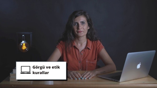 Bu görüntü, işyeri görgü kuralları ve etik eğitimi üzerine çevrimiçi bir kursu tasvir etmektedir. Bir kadın önünde açık bir dizüstü bilgisayarla masada oturmaktadır. Dizüstü bilgisayarın arkasında bir logo vardır ve arka planda siyah metinli beyaz bir işaret görülmektedir. Kadının üzerinde bir gömlek vardır ve sağında spiral ışıklı bir ampul bulunmaktadır. Resmin alt kısmına yakın bir yerde kadının elleri görülmektedir. Bu görüntü, dijital çağda işyeri görgü kuralları ve etik eğitiminin önemini ortaya koymaktadır. Çalışanlar temel bilgileri öğrenerek iş yerlerinin profesyonel ve saygılı kalmasını sağlayabilirler. Bu görselde tasvir edilen çevrimiçi kurs, konuya ilgi çekici ve kapsamlı bir genel bakış sağlamaktadır.