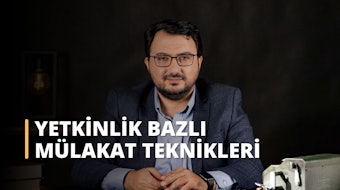 Bu görüntü takım elbiseli, gözlüklü ve elinde metal bir kutu tutan bir adamı tasvir etmektedir. Adamın gözleri görüntünün odak noktasıdır ve yakın planda bir saat de görülmektedir. Adam profesyonel ve kendinden emin görünüyor, muhtemelen bir işyeri ortamında. Görüntü bir başarı ve pozitiflik hissi uyandırıyor. Takım elbise, gözlük ve kutu başarı ve hırsı temsil ediyor olabilir. Genel olarak, bu görsel olarak çekici ve ilginç bir görüntüdür.