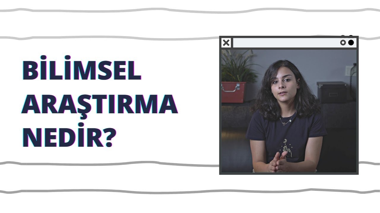 Bir kadın bilgisayar penceresinin önünde oturuyor, siyah bir gömlek giymiş ve uzun siyah saçları var. Ekrana bakıyor gibi görünüyor ve boynunda bir kolye var. Görüntünün arka planında mavi metinli beyaz bir duvar ve kadının yanında pencere kenarında bir bitki var. Bir kanepede oturuyor ve elleri dizlerinin üzerinde duruyor. Yüz ifadesi nötr ve bakışları bilgisayar ekranına odaklanmış durumda. Az miktarda ışık yüzünü aydınlatıyor ve görüntüdeki renkler soluk.